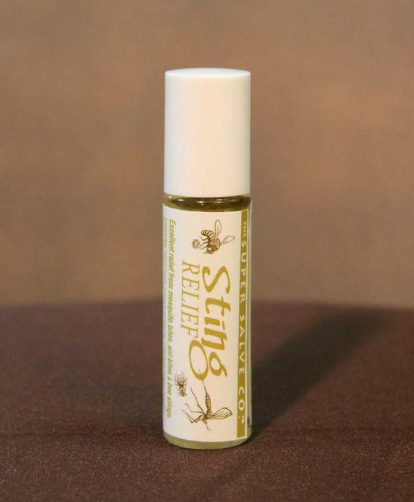 A glass tube of Sting Relief from the Super Salve Co., which is designed to provide relief from ant bites, mosquito bites, bee stings and any other insect bites or stings, is seen against a brown backdrop at Winter Sun Trading Co.