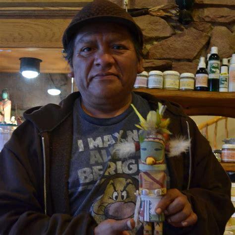 Philbert Honanie poses with a kachina doll he carved at Winter Sun in Flagstaff, Arizona