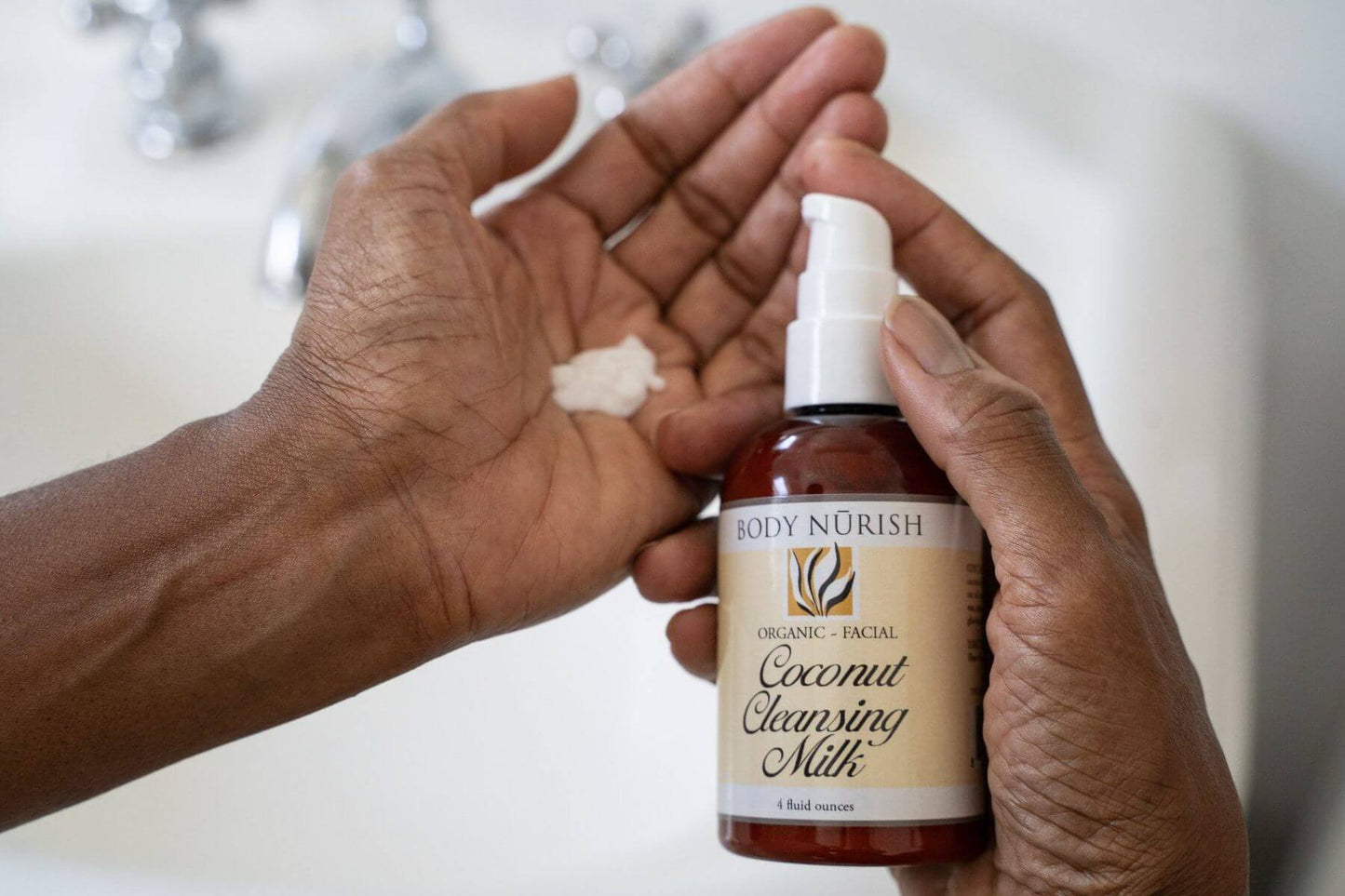 The coconut cleaning milk is being displayed in a woman's hand.