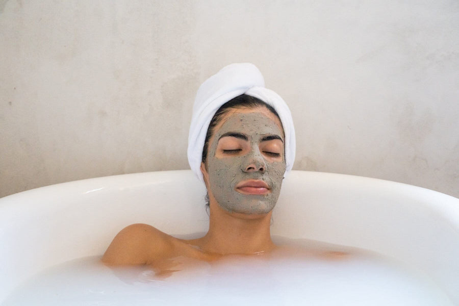 I woman Sits in the bath look relaxed with the Body Nurish Green Clay Refinisher Mask on her face.