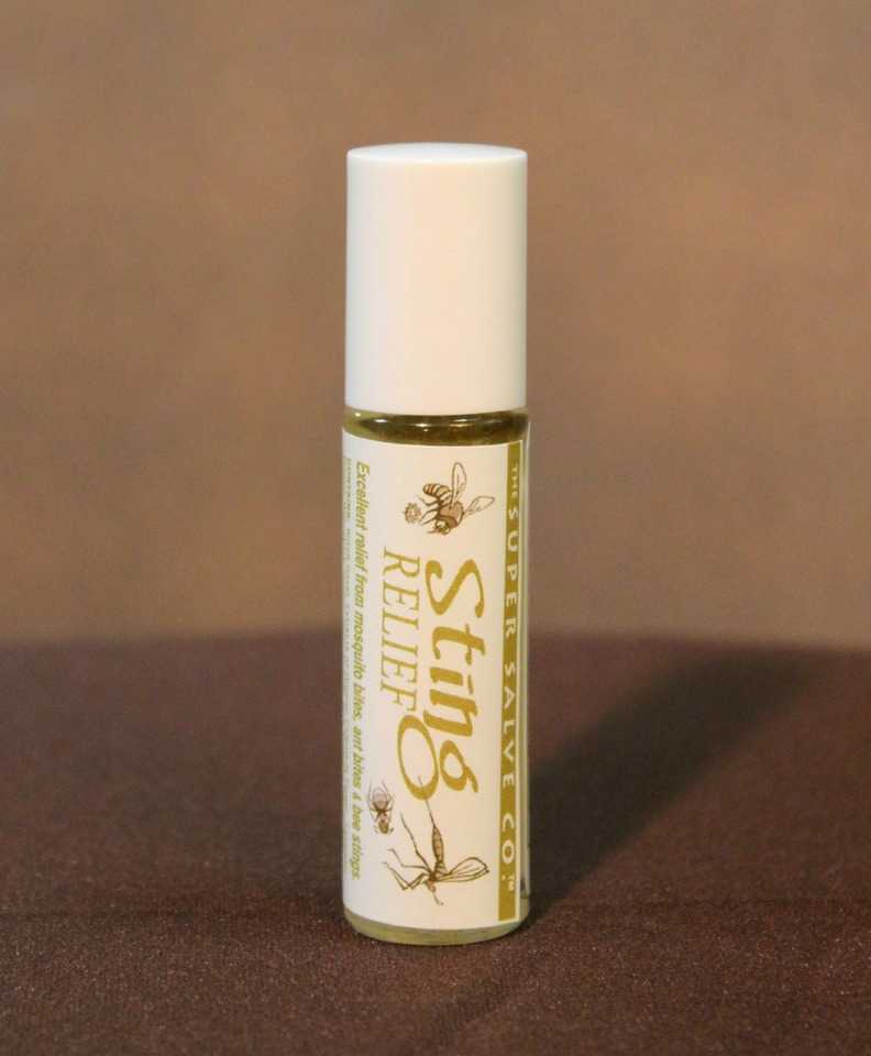 A glass tube of Sting Relief from the Super Salve Co., which is designed to provide relief from ant bites, mosquito bites, bee stings and any other insect bites or stings, is seen against a brown backdrop at Winter Sun Trading Co.