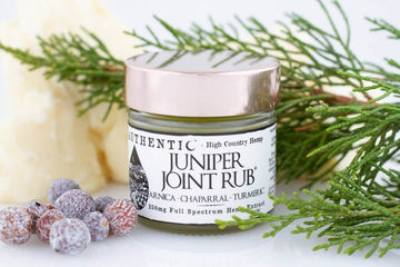 Juniper Joint Rub 250 mg container with juniper leaves and berries spread around it