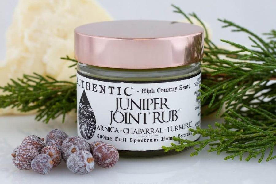 Juniper Joint Rub 500 mg container with juniper leaves and berries spread around it