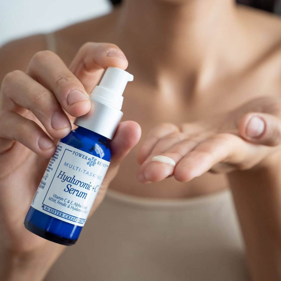 A woman with smooth skin pumps a small amount of Power Repair hyaluronic acid serum on her hand
