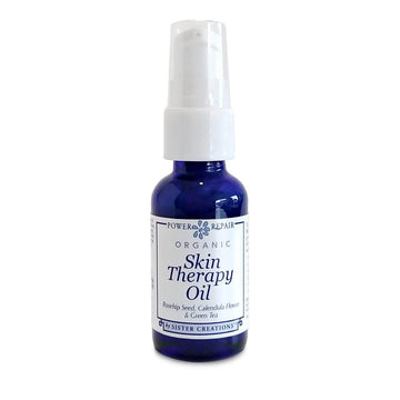A blue 1 oz. pump bottle of Power Repair Organic Skin Therapy Oil from Sister Creations is seen against a white backdrop at Winter Sun Trading Co.