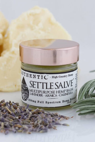 Settle Salve 250 mg jar with beautiful plants displayed around it