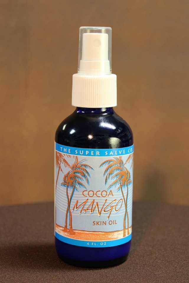 A blue 4 oz. pump spray bottle of Cocoa Mango Skin Oil by The Super Salve Co. 